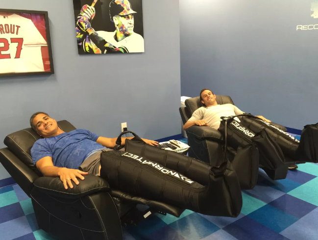 David Bunevacz y Tom Danford haciendo la compresión Normatec en septiembre de 2016.(Meredith Danford)